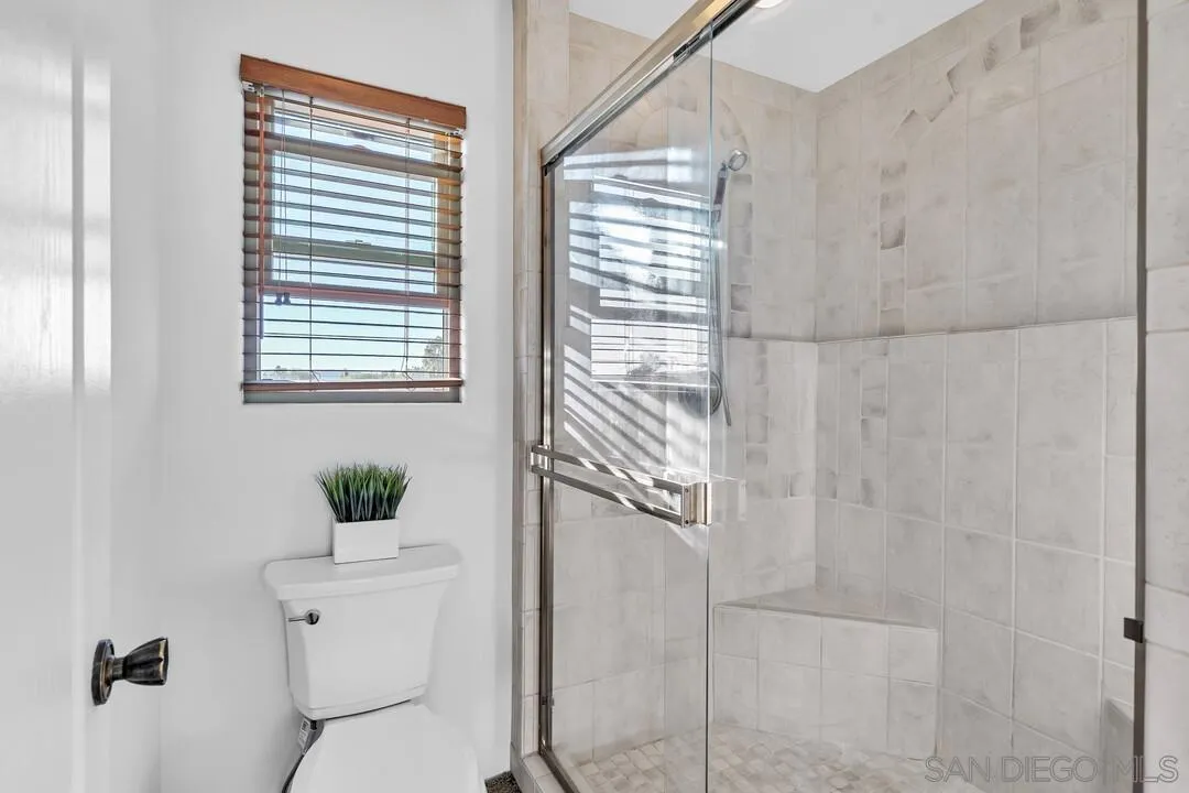 13419 Sebago Avenue Poway, CA 92064 - Photo 34 of 49 a bathroom with a shower curtain and a toilet