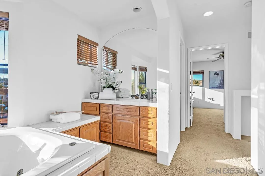 13419 Sebago Avenue Poway, CA 92064 - Photo 35 of 49 a spacious bathroom with a granite countertop sink and a mirror