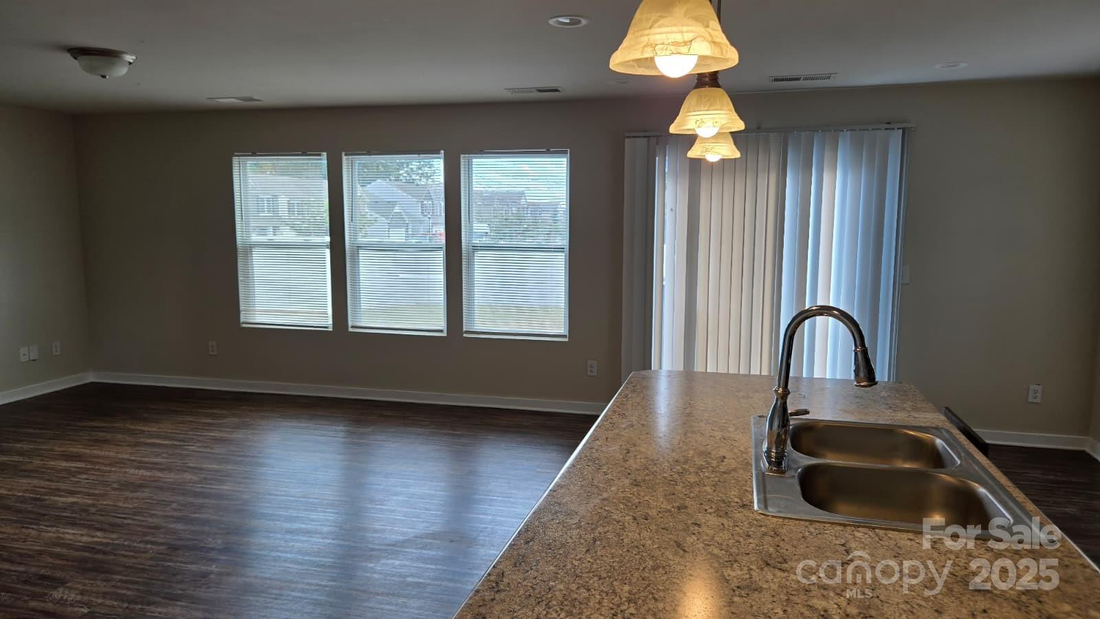 705 Anglin Forest Way Charlotte, NC 28214 - Photo 13 of 36 a kitchen with a sink a chandelier and wooden floor