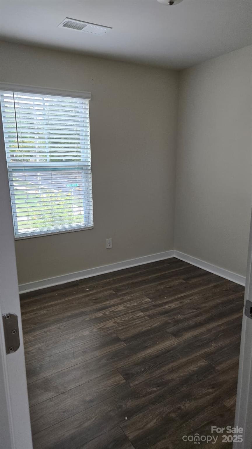 705 Anglin Forest Way Charlotte, NC 28214 - Photo 17 of 36 a view of an empty room with wooden floor and a window