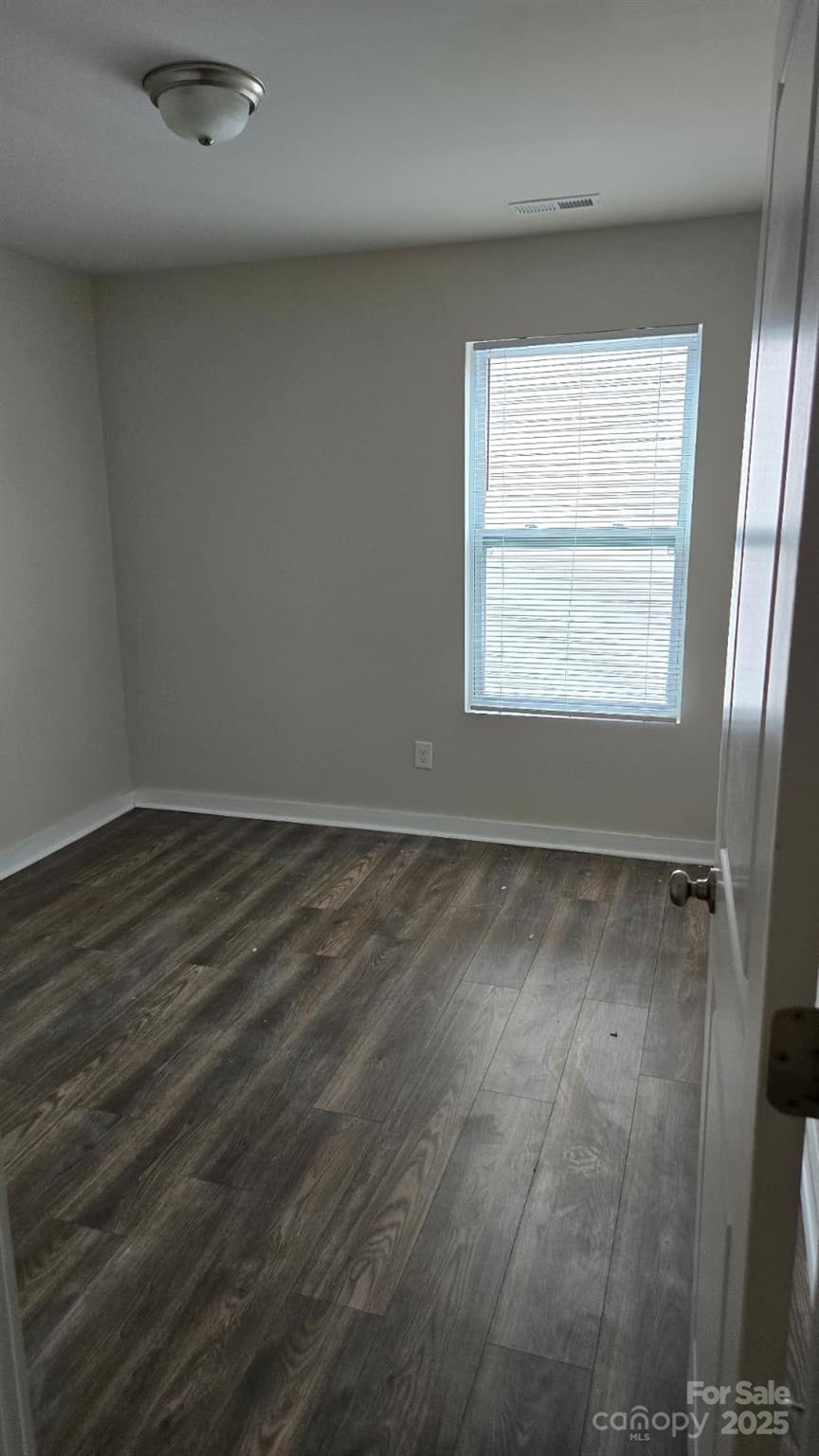 705 Anglin Forest Way Charlotte, NC 28214 - Photo 22 of 36 an empty room with wooden floor and windows