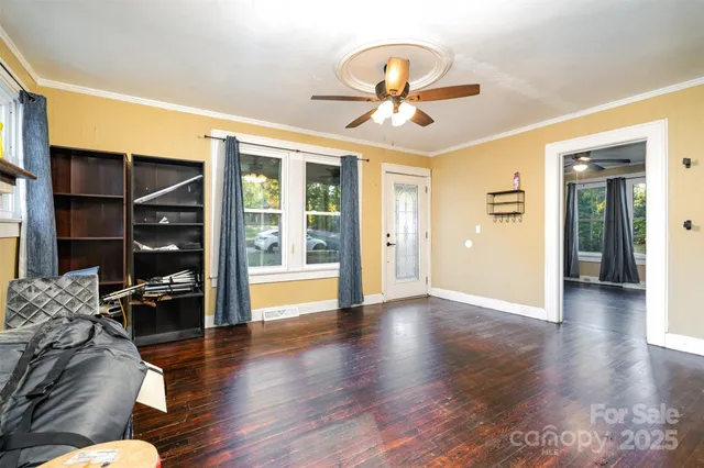 a view of a livingroom with wooden floor and a ceiling fan