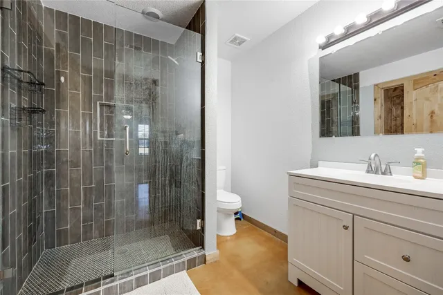 a view of a patio with a table chairs potted plants and floor to ceiling window