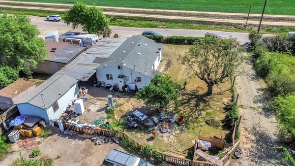 an aerial view of a house with a yard and a large tree