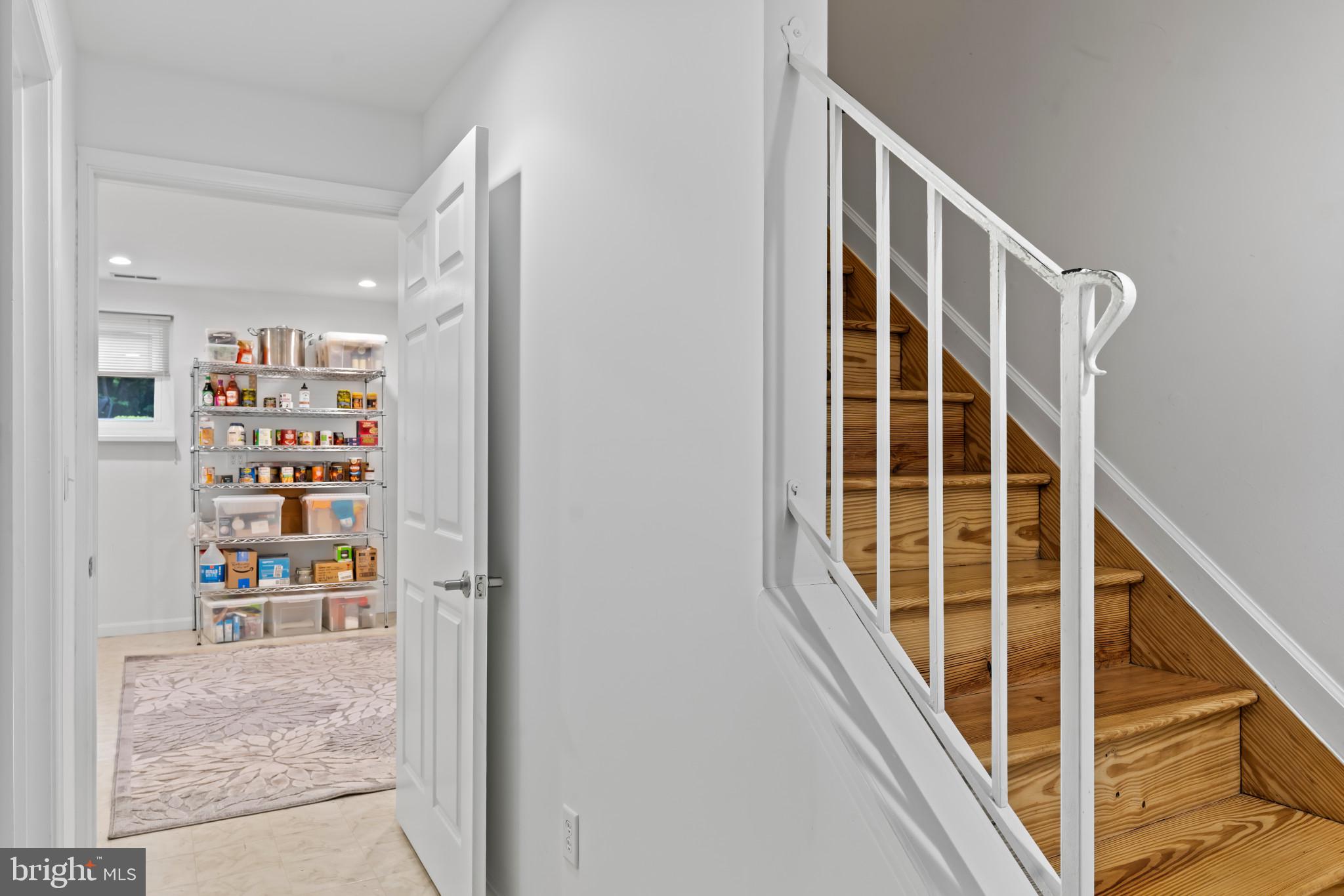 10821 Braeburn Road Columbia, MD 21044 - Photo 50 of 64 a view of staircase with wooden floor and lots of frames on wall