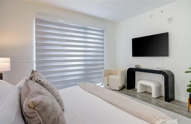 a bedroom with a chair and a television