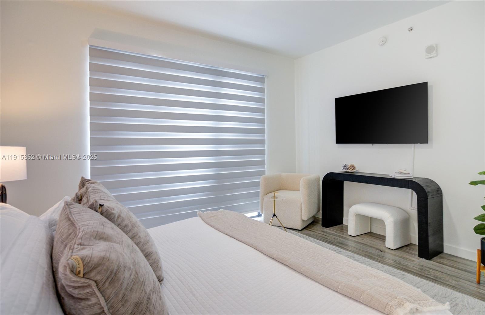 2955 Bird Avenue, Unit 2B Miami, FL 33133 - Photo 7 of 16 a bedroom with a chair and a television