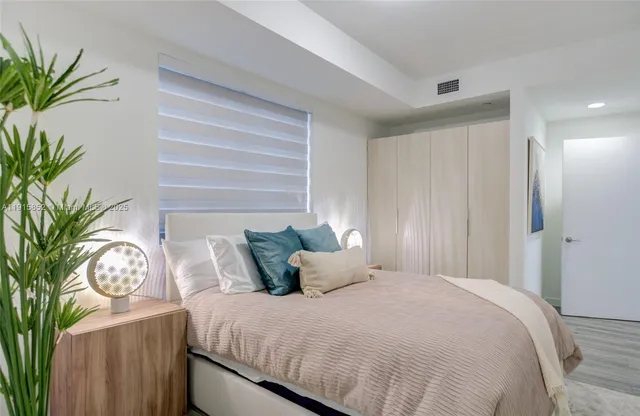 a bedroom with bed and a potted plant