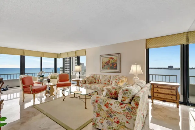 a view of a livingroom with a chandelier fan and windows
