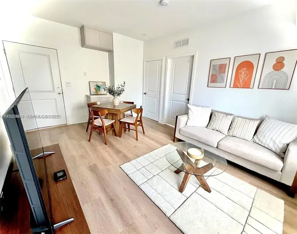 a living room with furniture and wooden floor