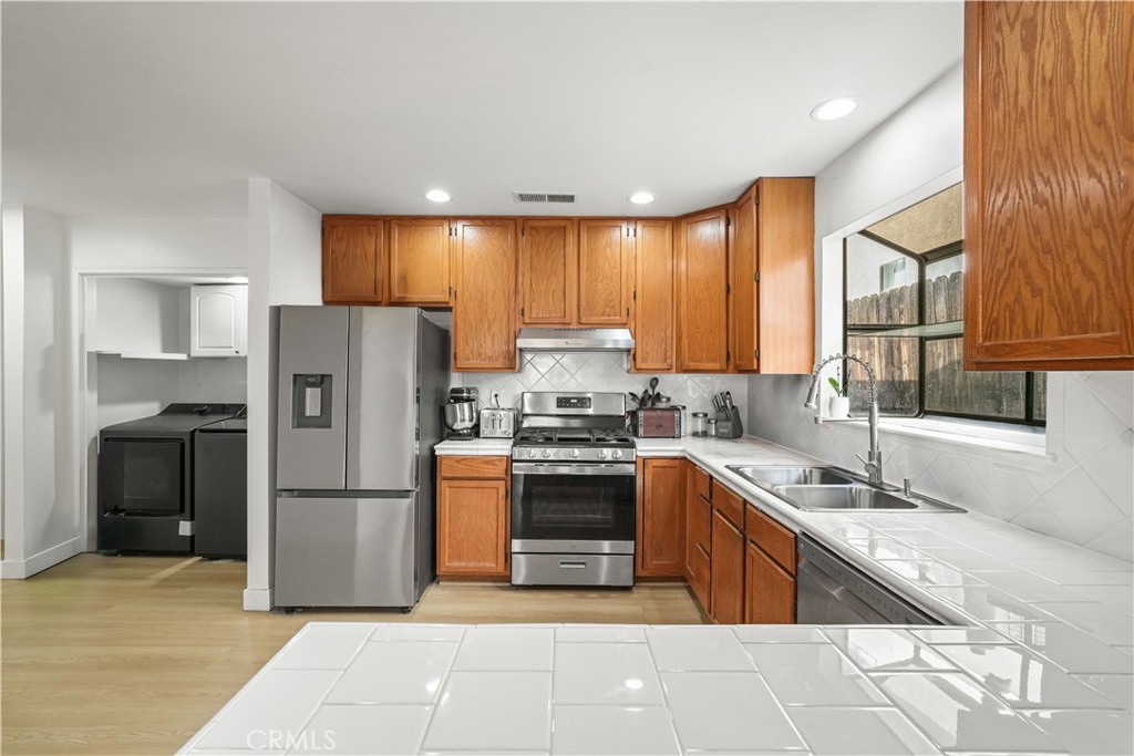 30257 Trellis Road Val Verde, CA 91384 - Photo 13 of 20 a kitchen with a sink a refrigerator and a sink