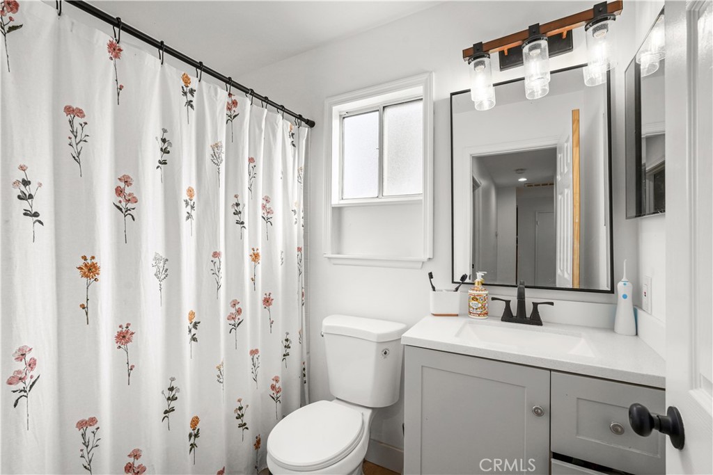 30257 Trellis Road Val Verde, CA 91384 - Photo 17 of 20 a bathroom with a sink a toilet and shower curtain