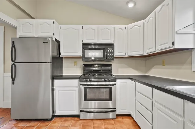 a kitchen with white cabinets and white appliances