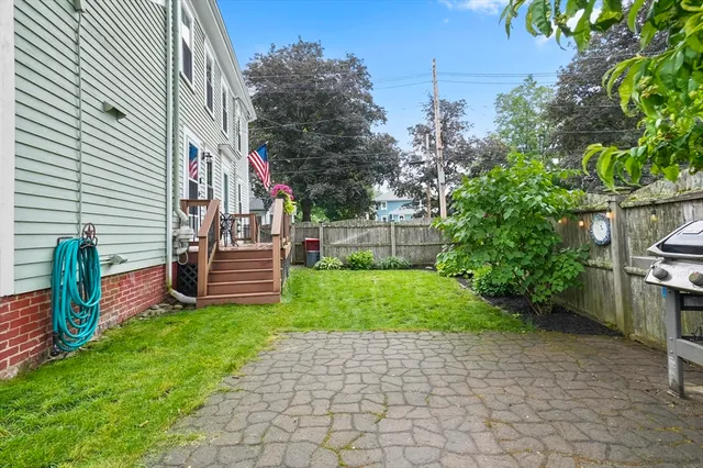 a view of a back yard of the house with a bench