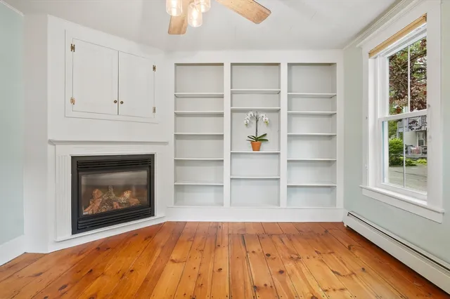 a view of an empty room with a fireplace and a window