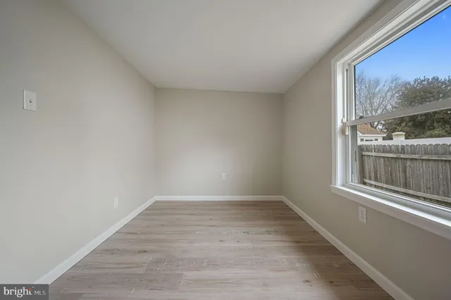 a view of a room that has wooden floor and a window