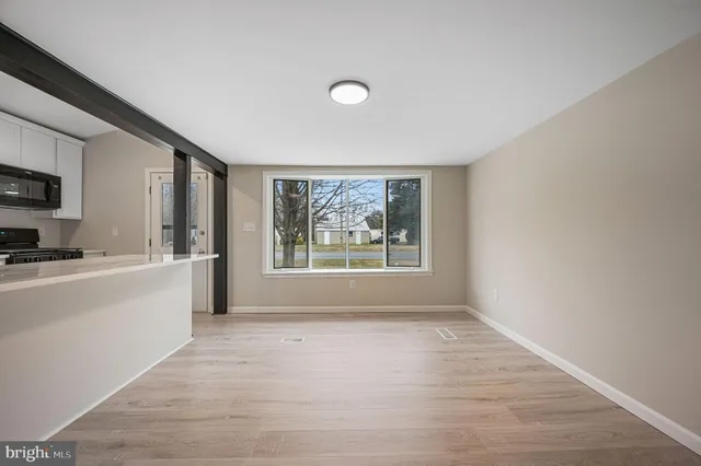 a view of a kitchen with microwave and windows