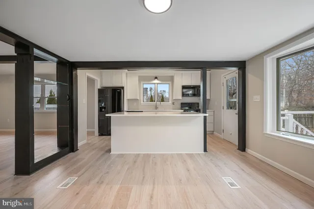 a view living room with granite countertop wooden floor and kitchen view