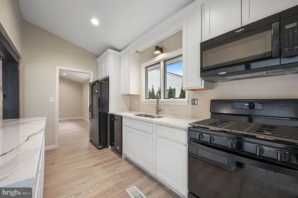 a kitchen with stainless steel appliances a stove cabinets and a sink