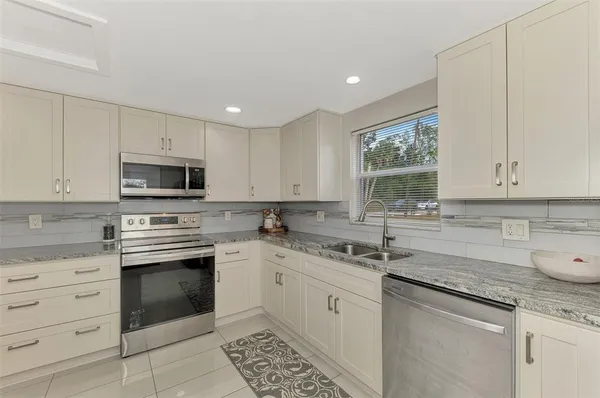 a kitchen with a sink stove and microwave