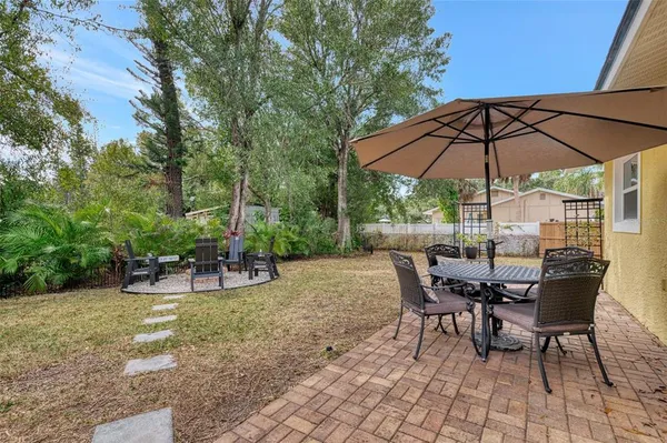 a view of patio with chairs and table under an umbrella