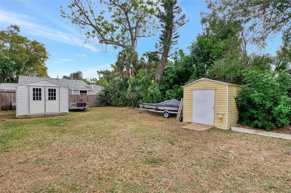 a view of a house with backyard and trees