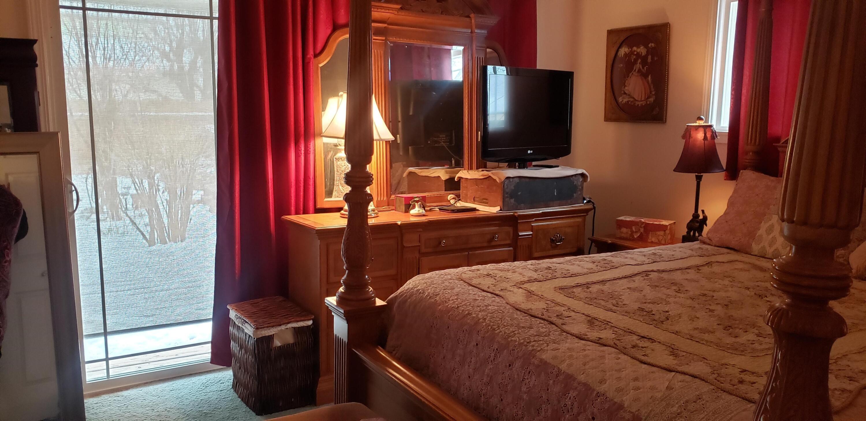 24924 Curve Street Fall River Mills, CA 96028 - Photo 13 of 25 a bedroom with a bed and a flat tv screen on dresser