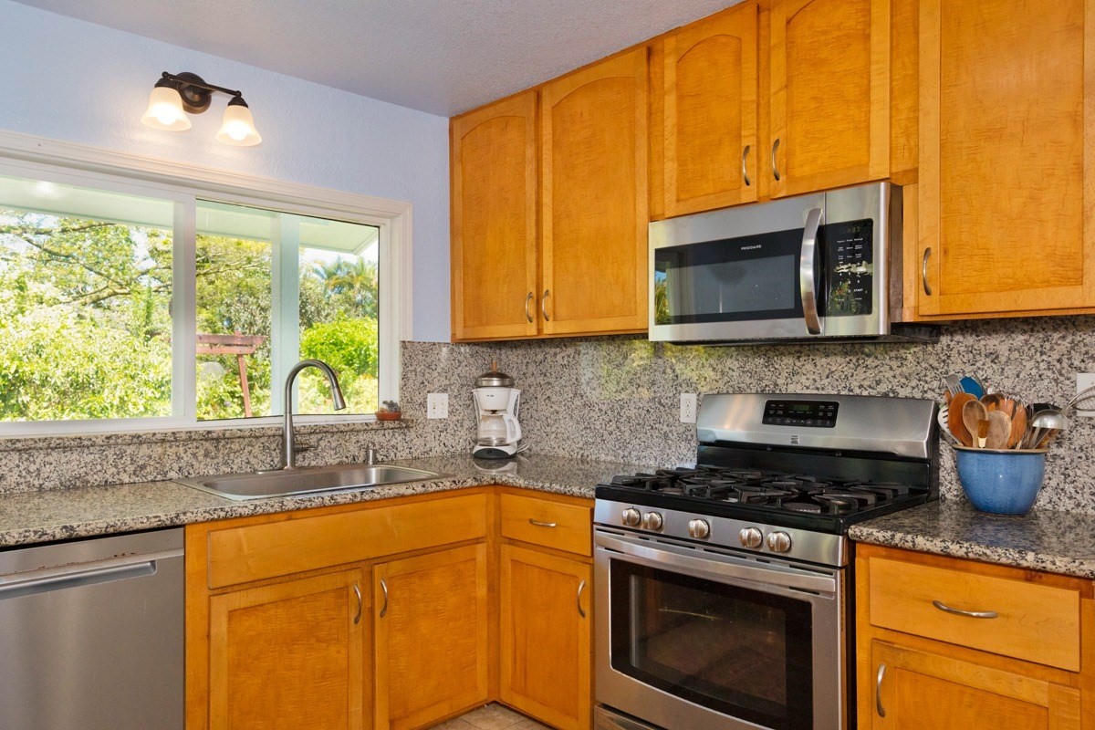20 Hoaka Road Hilo, HI 96720 - Photo 6 of 30 a kitchen with stainless steel appliances granite countertop a stove a sink and a microwave