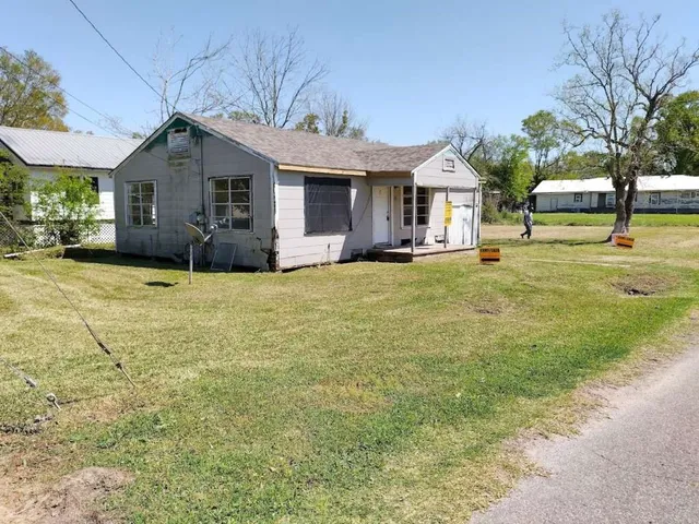 a view of a house with a yard and sitting area