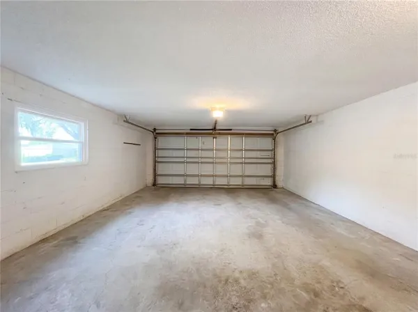 an empty room with wooden floor ceiling fan and windows