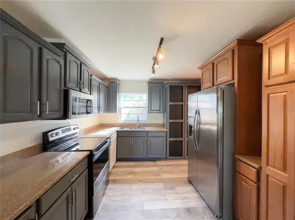 a kitchen with stainless steel appliances granite countertop a refrigerator stove and sink