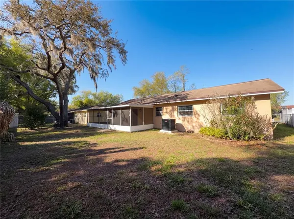a view of a house with backyard and trees