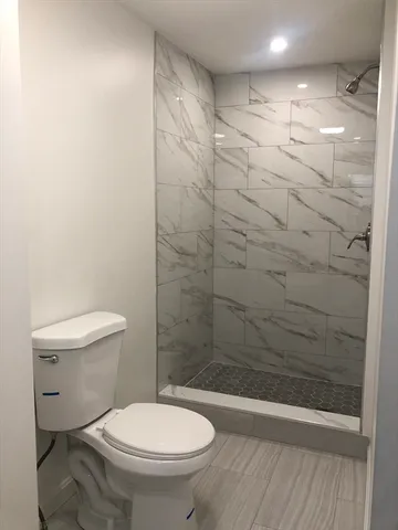 a bathroom with a toilet and a shower