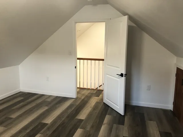 a view of a room with wooden floor and a window