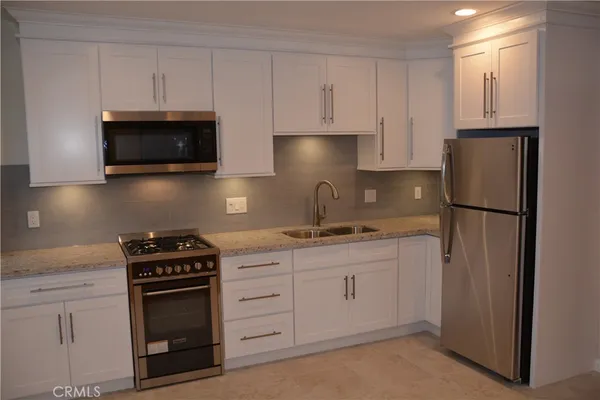 a kitchen with white cabinets and stainless steel appliances