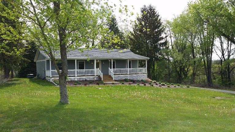 75 South Smoke Road Kouts, IN 46347 - Photo 1 of 10 a front view of a house with a garden and trees