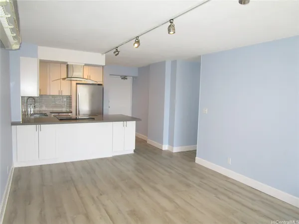 a view of a kitchen with wooden floor and electronic appliances