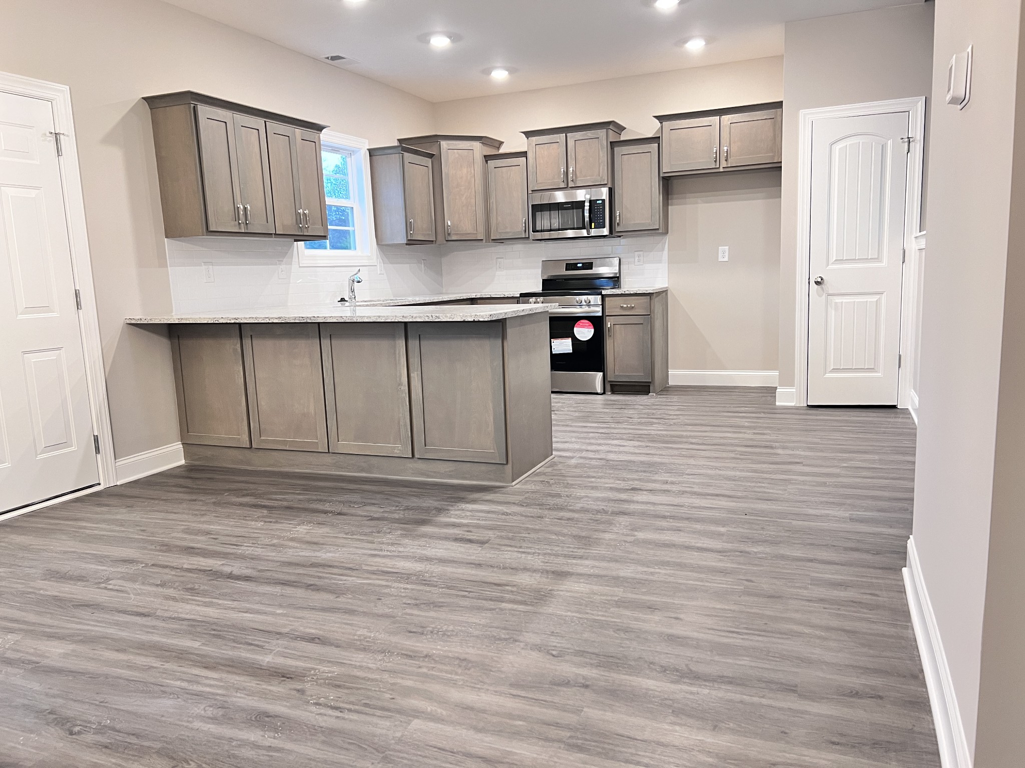 442 Generosity Way Smyrna, TN 37167 - Photo 19 of 59 a kitchen with stainless steel appliances kitchen island granite countertop a stove a sink and white cabinets