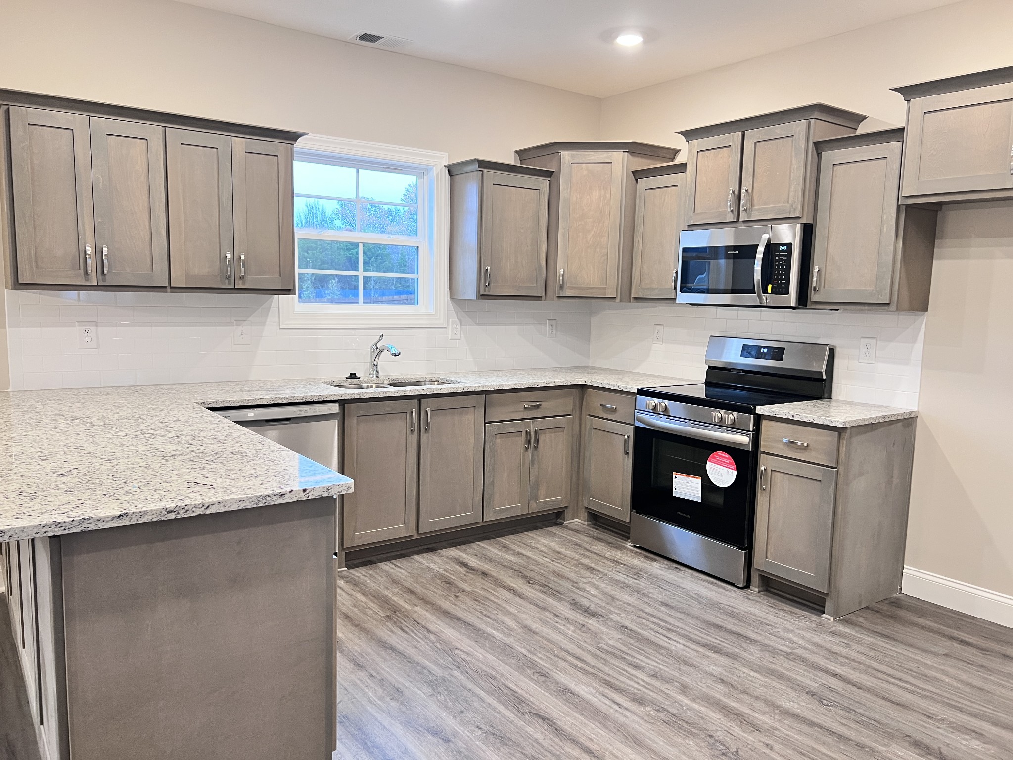 442 Generosity Way Smyrna, TN 37167 - Photo 34 of 59 a kitchen with stainless steel appliances granite countertop a sink dishwasher stove and oven with wooden floor