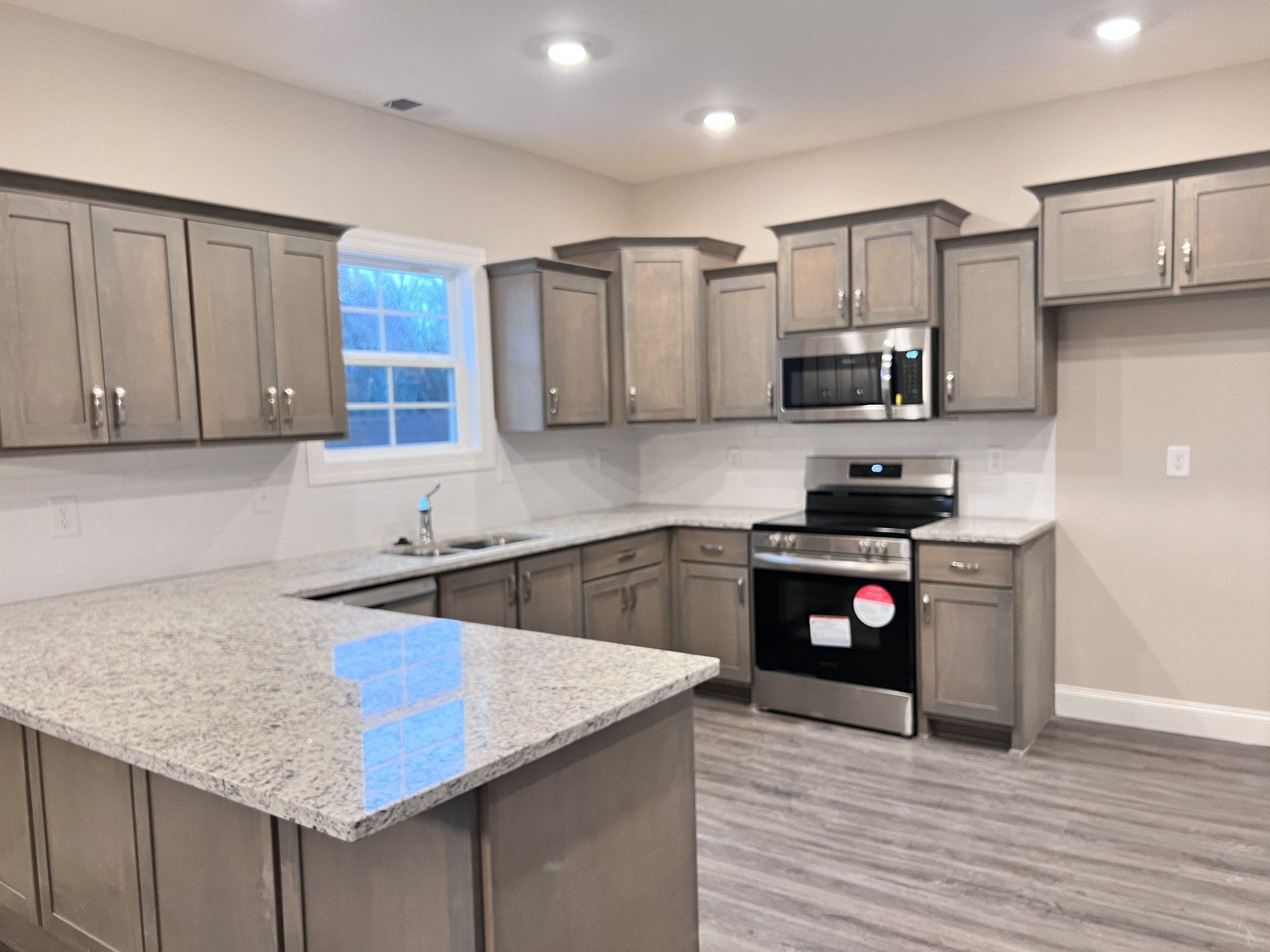 442 Generosity Way Smyrna, TN 37167 - Photo 5 of 59 a kitchen with granite countertop a stove top oven a sink dishwasher and cabinets with wooden floor