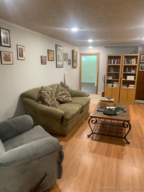 62 Cedarwood Road Berlin, CT 06037 - Photo 26 of 37 a living room with furniture hard wood floor and a book shelf