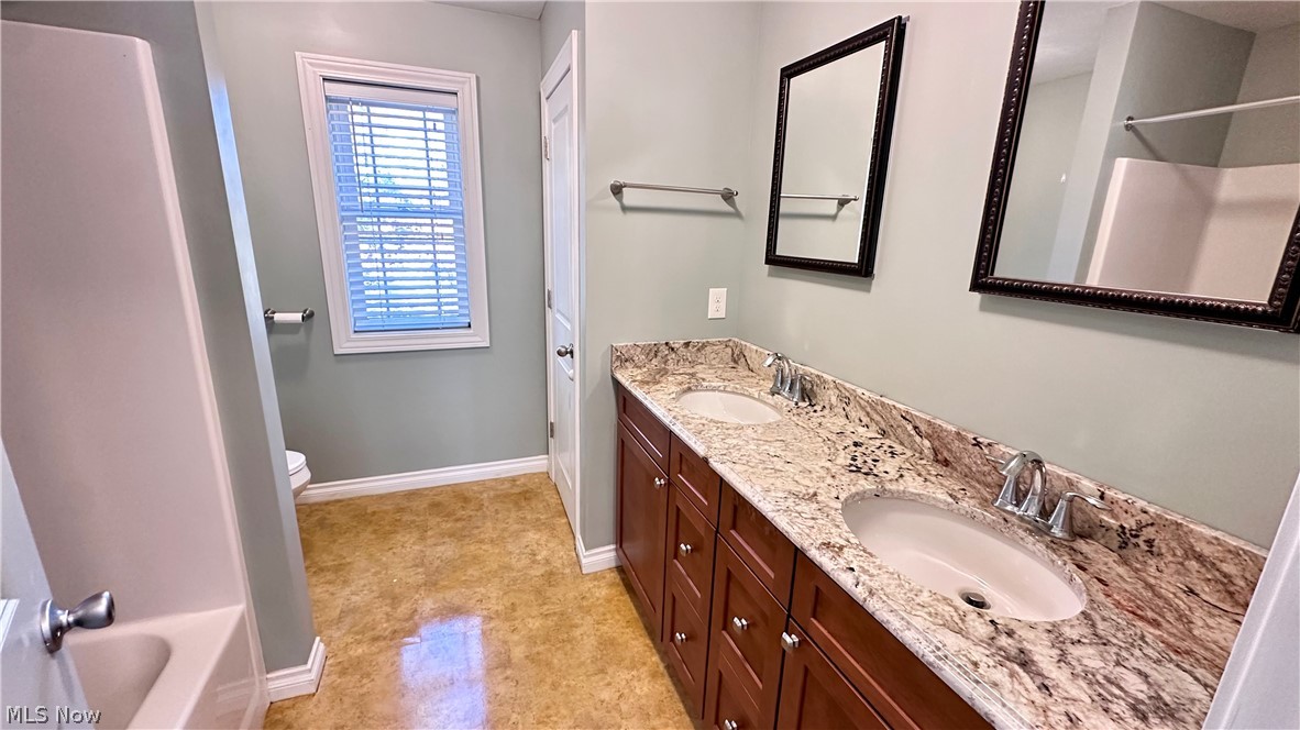 2603 Rockefeller Road Wickliffe, OH 44092 - Photo 21 of 34 Dual vanity with undermount sinks, stone countertops, and wood-finish cabinetry