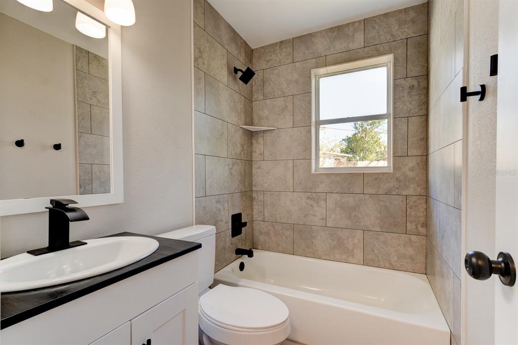 13 Highridge Road Daytona Beach, FL 32117 - Photo 20 of 27 a bathroom with a bathtub shower sink vanity and toilet