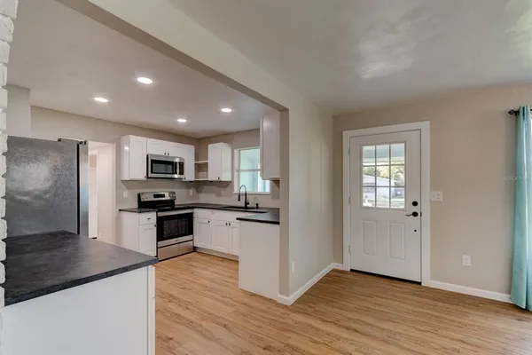 a kitchen with stainless steel appliances granite countertop a refrigerator stove top oven and sink