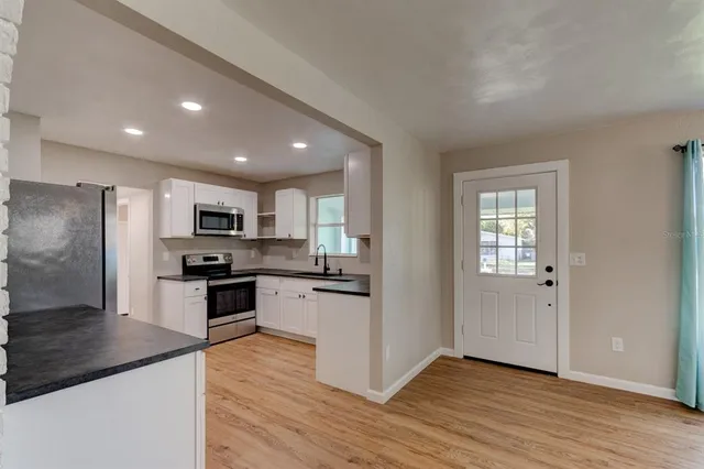 a kitchen with stainless steel appliances granite countertop a refrigerator stove top oven and sink