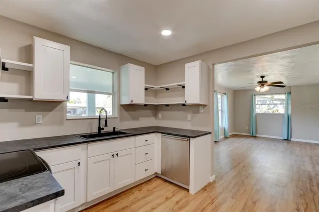 a kitchen with granite countertop white cabinets and white appliances