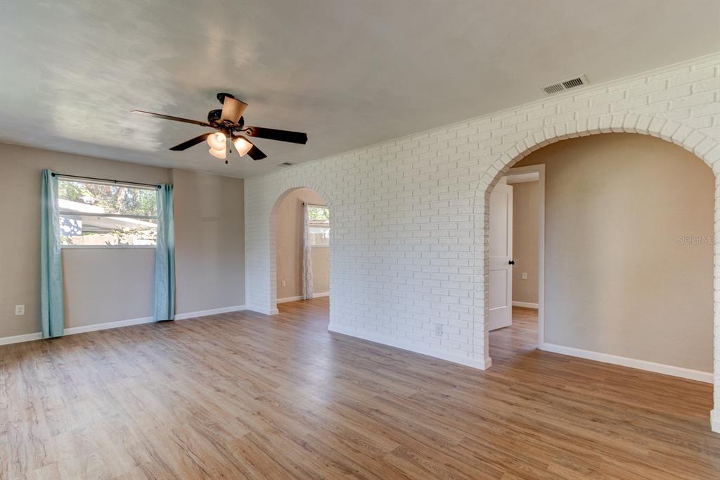13 Highridge Road Daytona Beach, FL 32117 - Photo 7 of 27 a view of an empty room with wooden floor and a window