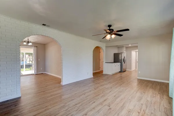 a view of a livingroom with wooden floor and a ceiling fan