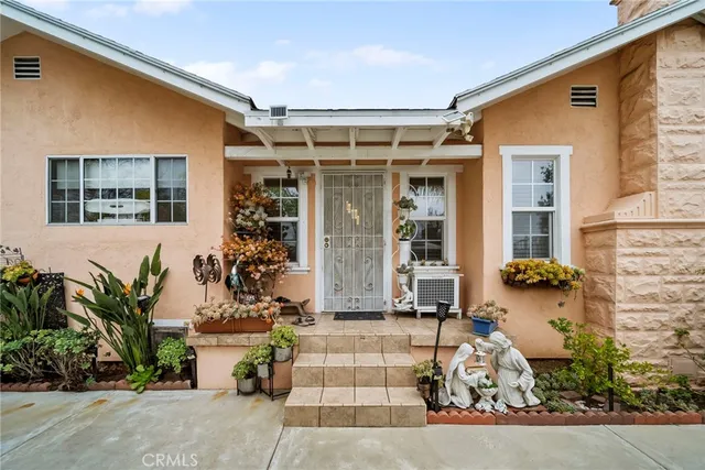 a view of a house with a yard and potted plants