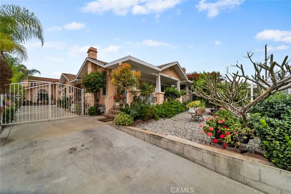 a view of a house with a yard and potted plants
